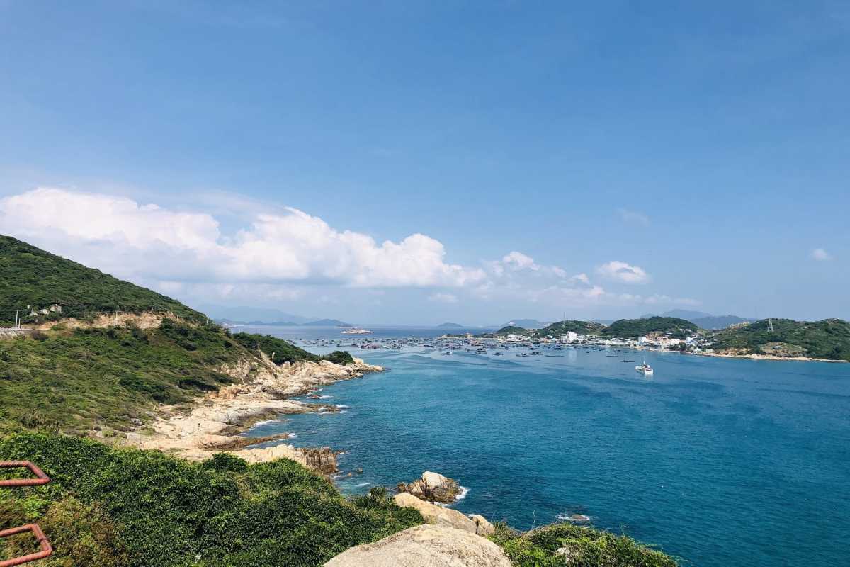 Vinh Hy Bay rocky cliffs and clear blue sea Rocky cliffs framing the clear blue sea at Vinh Hy Bay, a perfect spot for sightseeing