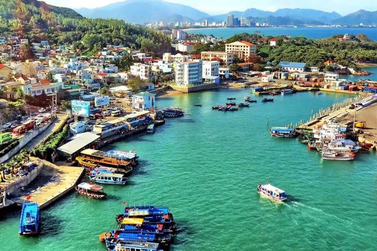 Aerial View of Vĩnh Lương Port Bird’s-eye view of Vĩnh Lương port showing buildings, piers, and turquoise water with fishing boats.