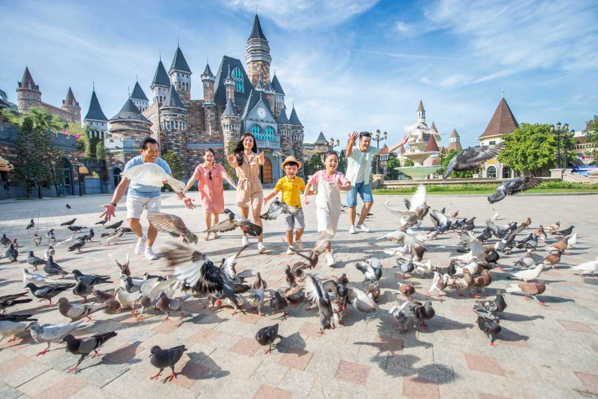 VinWonders Castle Square with Families and Birds Families enjoying time with birds at VinWonders Nha Trang Castle Square under clear blue skies
