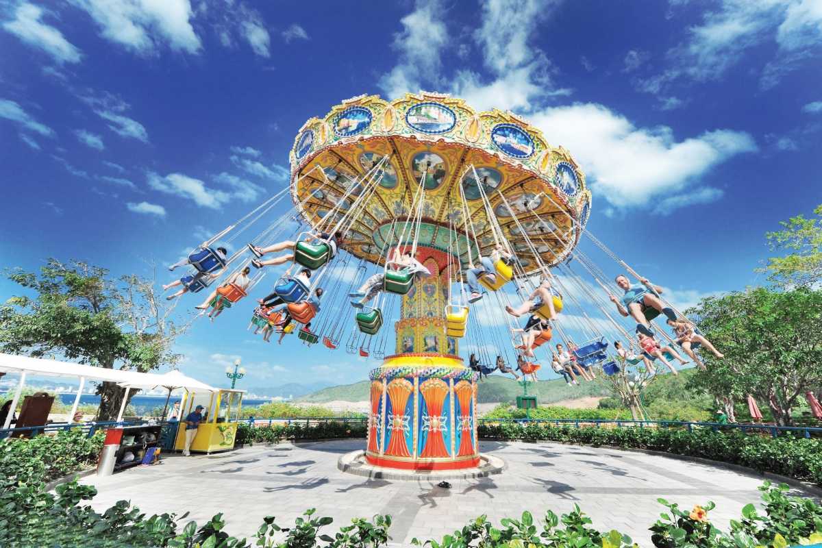 VinWonders Swing Ride Zone Guests enjoying a giant colorful swing ride against a bright sky at VinWonders Nha Trang