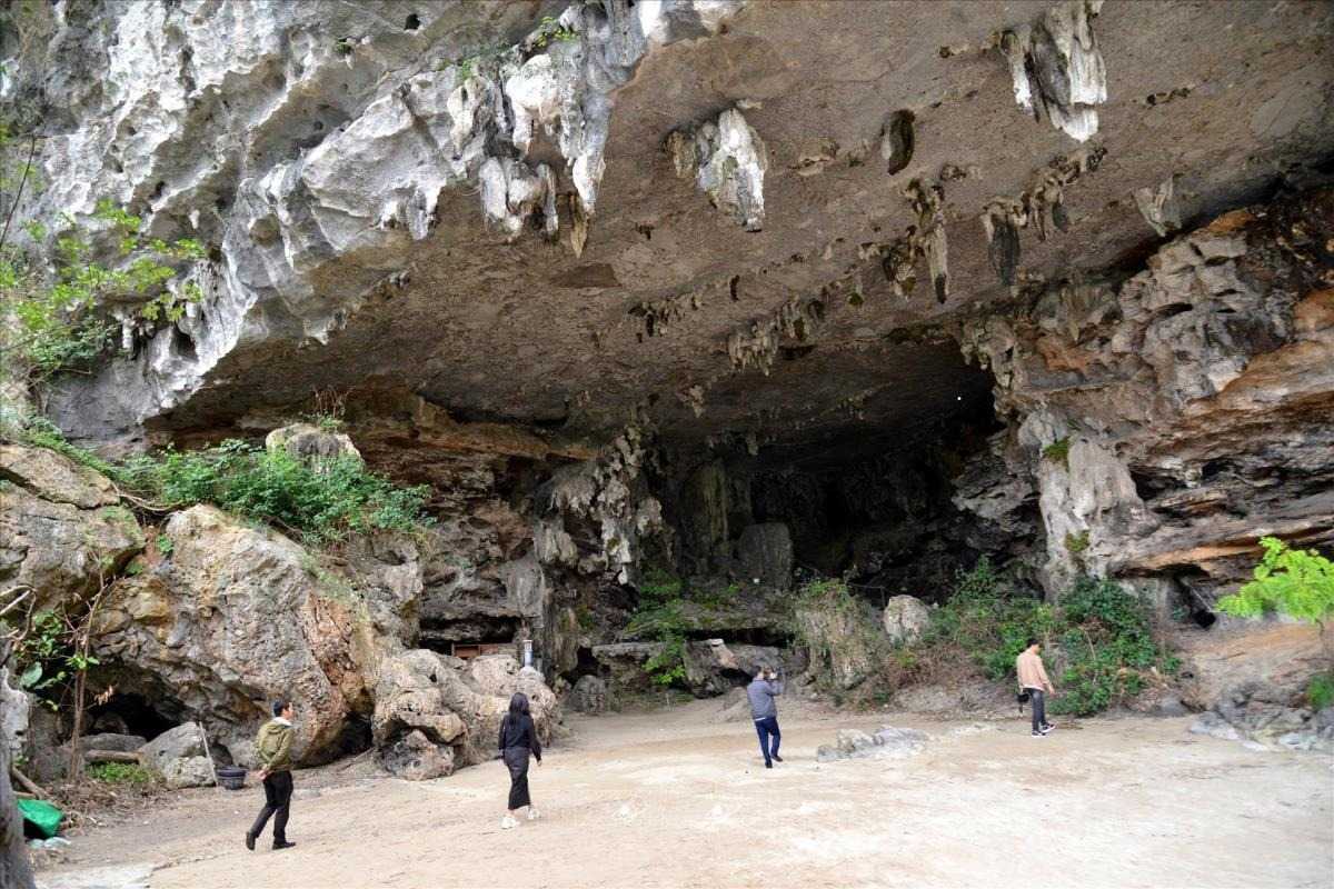 Virgin Cave Halong Bay tourists exploring cave entrance Tourists exploring the cave entrance and surroundings of Virgin Cave Halong Bay
