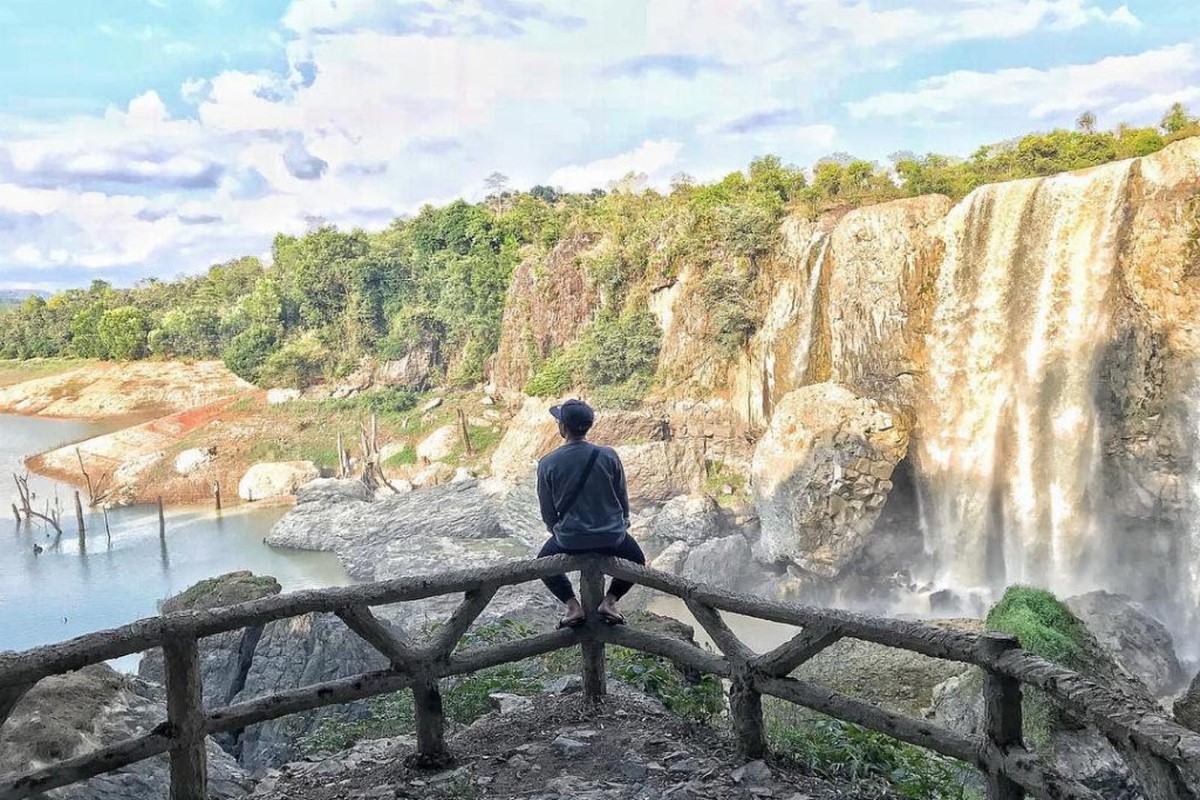 Visitor overlooking Bao Dai Waterfall and jungle scenery