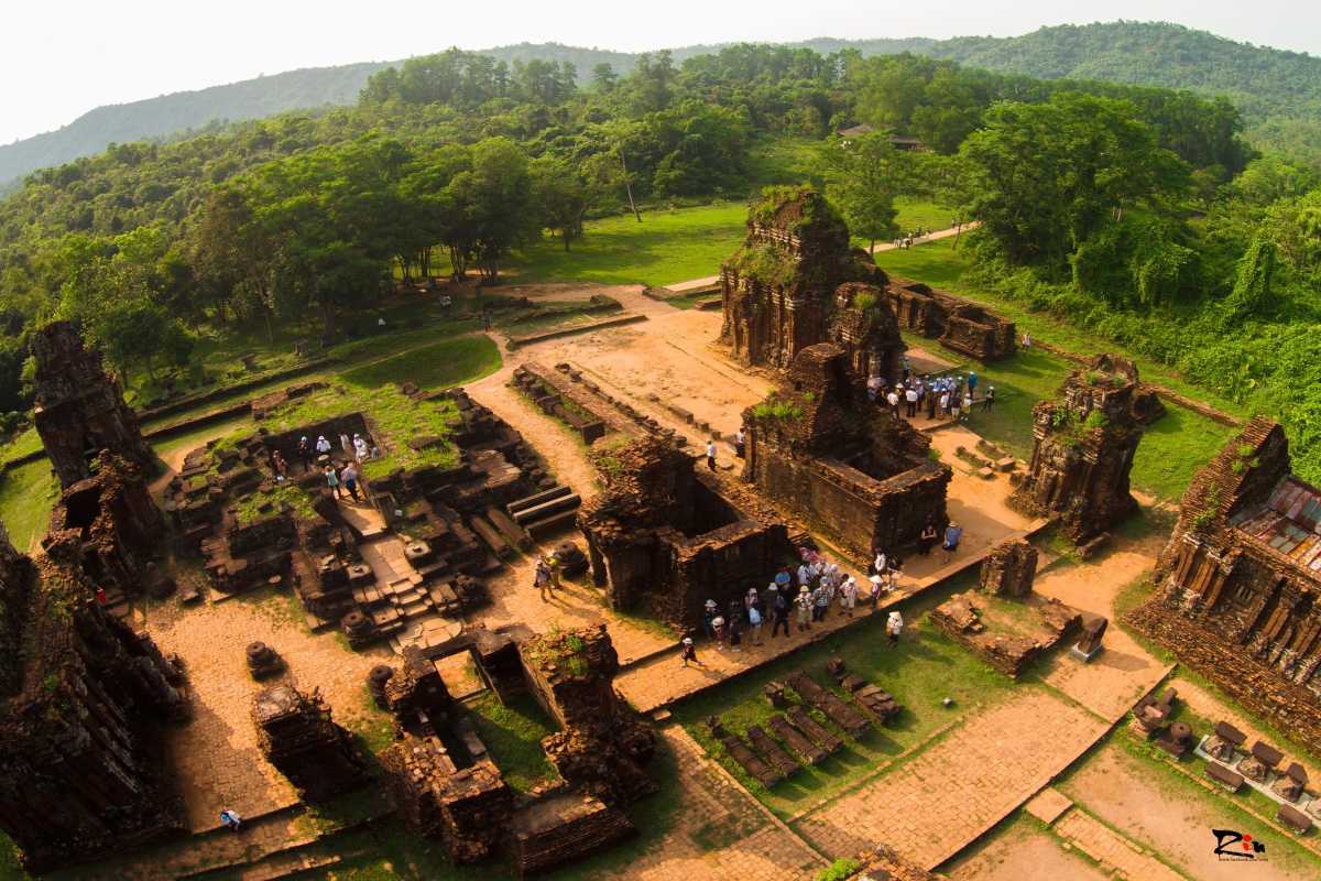 Visitors Exploring My Son Sanctuary Archaeological Site Tourists walking and exploring the archaeological ruins of My Son Sanctuary on a sunny day