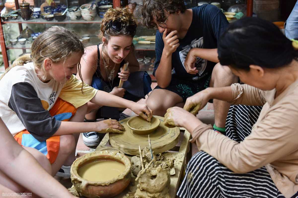 Visitors Participating in Pottery Workshop at Thanh Ha Group of visitors learning pottery making hands-on with local artisans at Thanh Ha Pottery Village