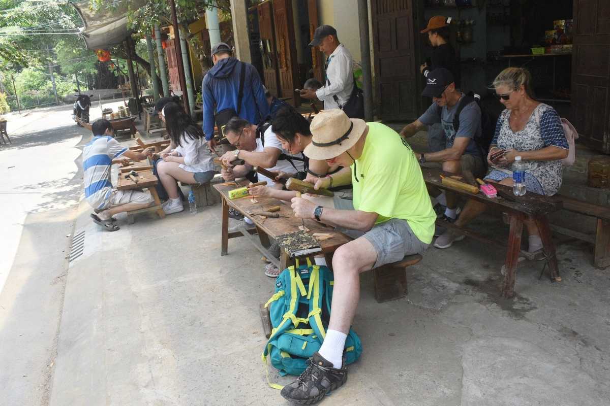 Visitors Participating in Woodworking Workshop Tourists learning traditional woodworking skills during a workshop at Kim Bong Carpentry Village