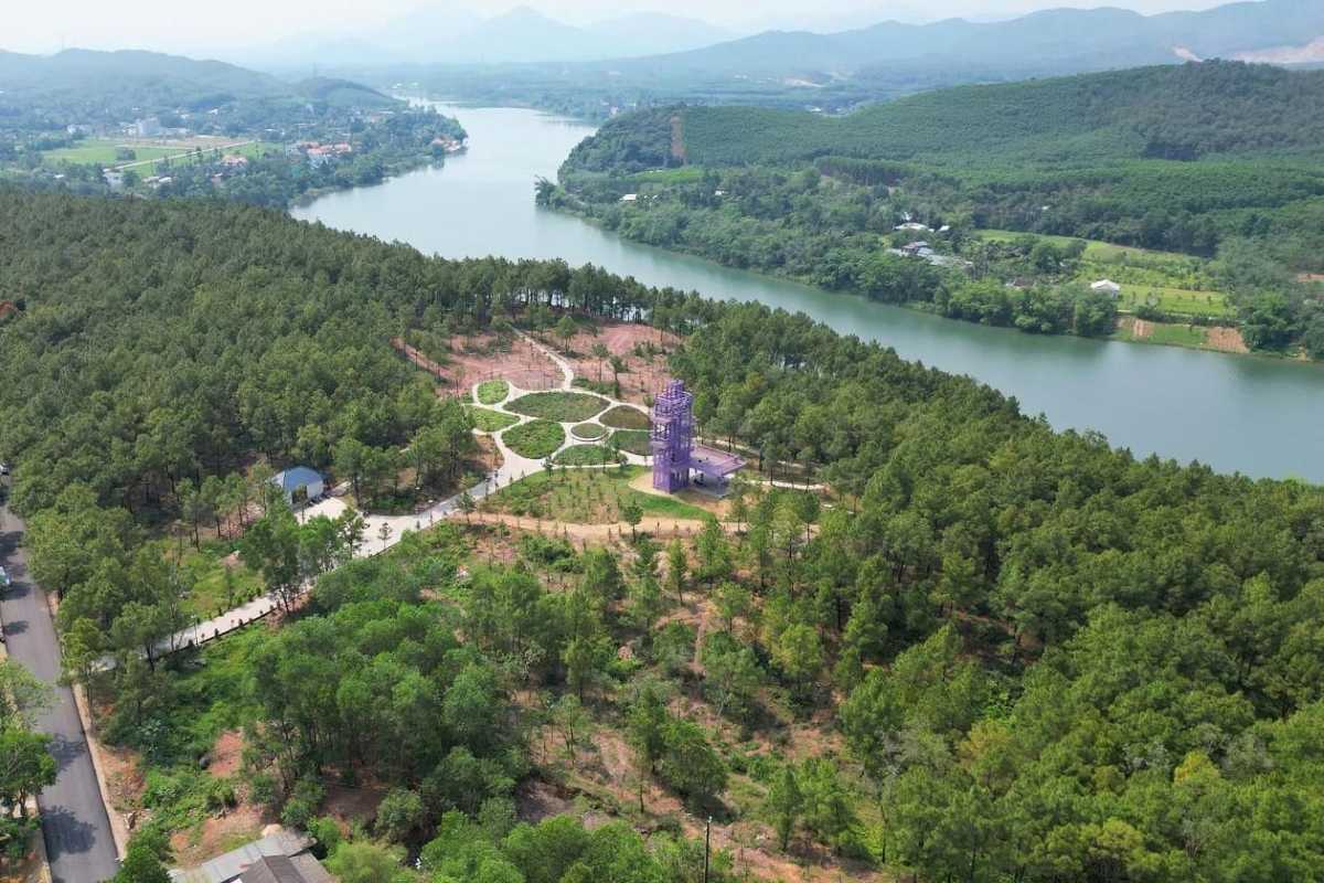 Vong Canh Hill Hue panoramic aerial view and pine gardens Vong Canh Hill Hue displays an aerial view of pine gardens, winding pathways, and the Perfume River set against distant hills.