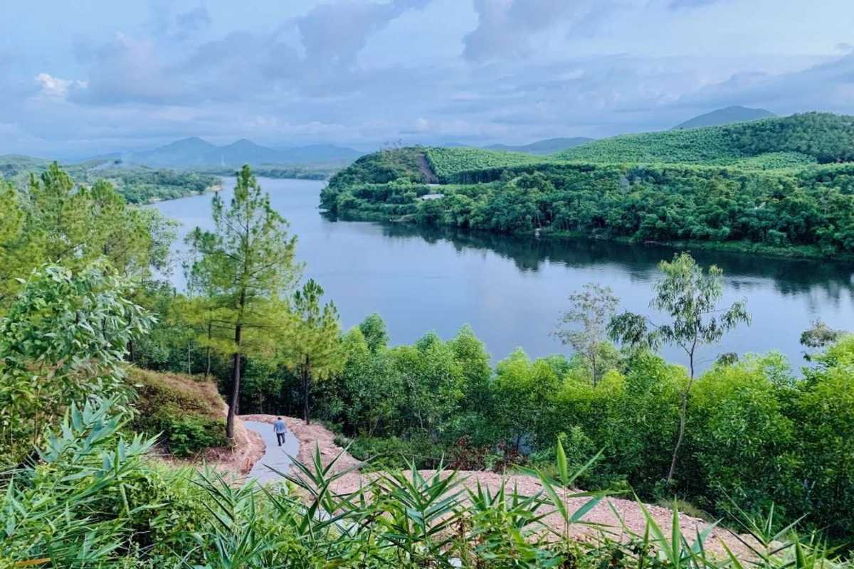 Vong Canh Hill Hue pathway view over river and hills A winding path at Vong Canh Hill Hue leads down through trees to sweeping views of the Perfume River and forested green hills.