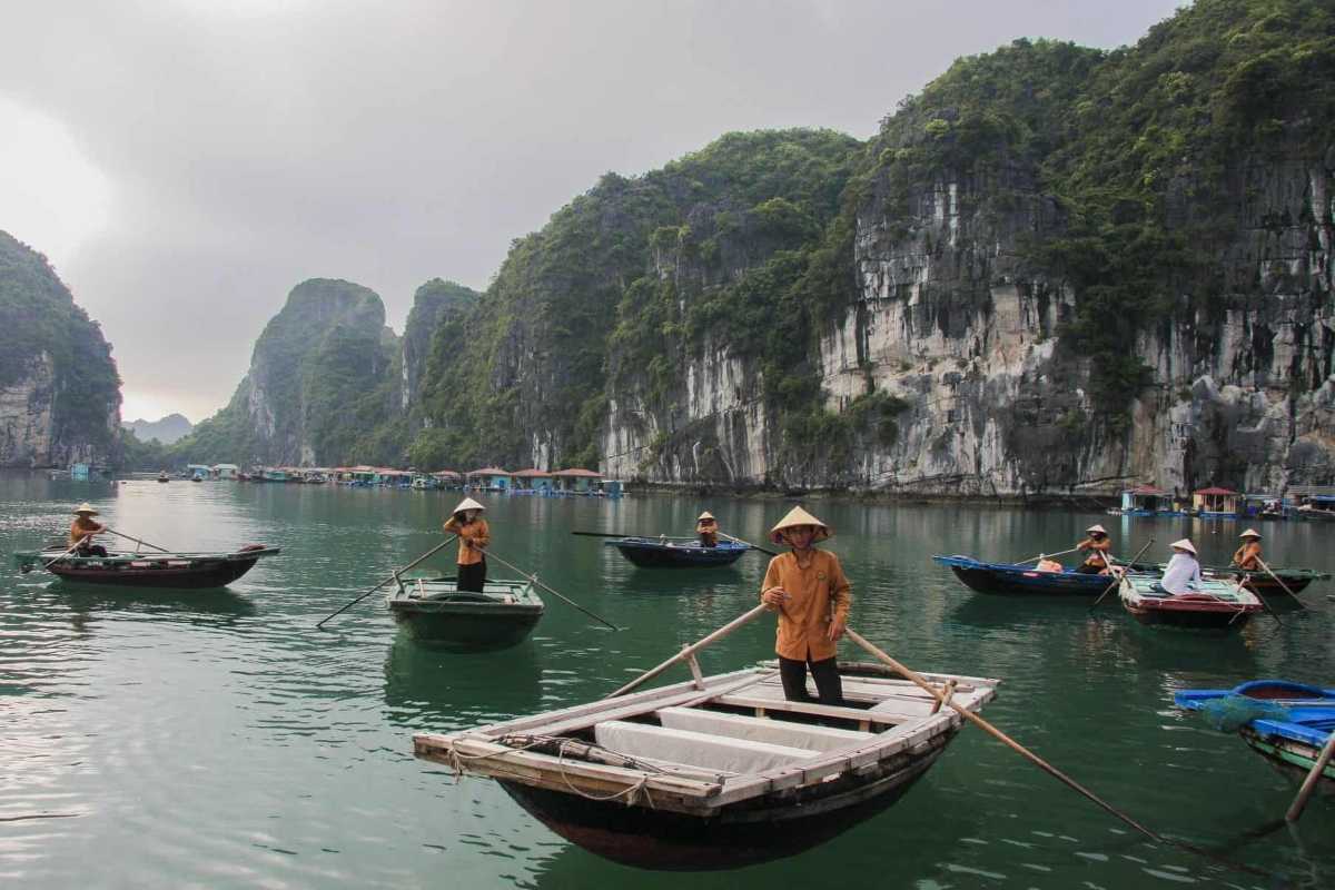 Vung Vieng Fishing Village boat arriving at floating village Boat carrying visitors arriving at Vung Vieng Fishing Village on Halong Bay surrounded by limestone karsts