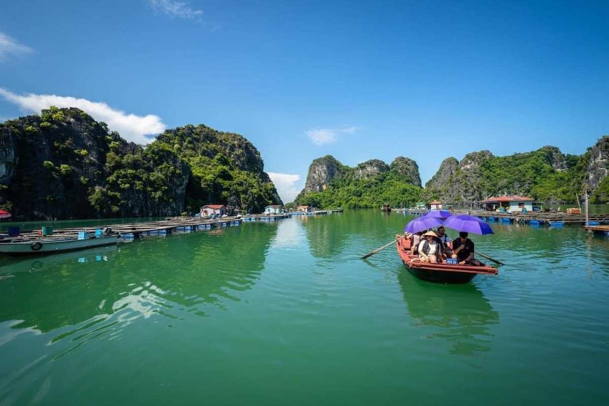 Vung Vieng Fishing Village rowboats with visitors Visitors in rowboats touring Vung Vieng Fishing Village surrounded by limestone cliffs on Halong Bay