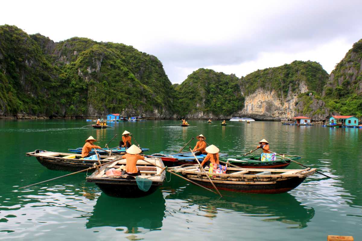 Vung Vieng Fishing Village scenic limestone backdrop Scenic limestone cliffs behind floating homes at Vung Vieng Fishing Village on Halong Bay