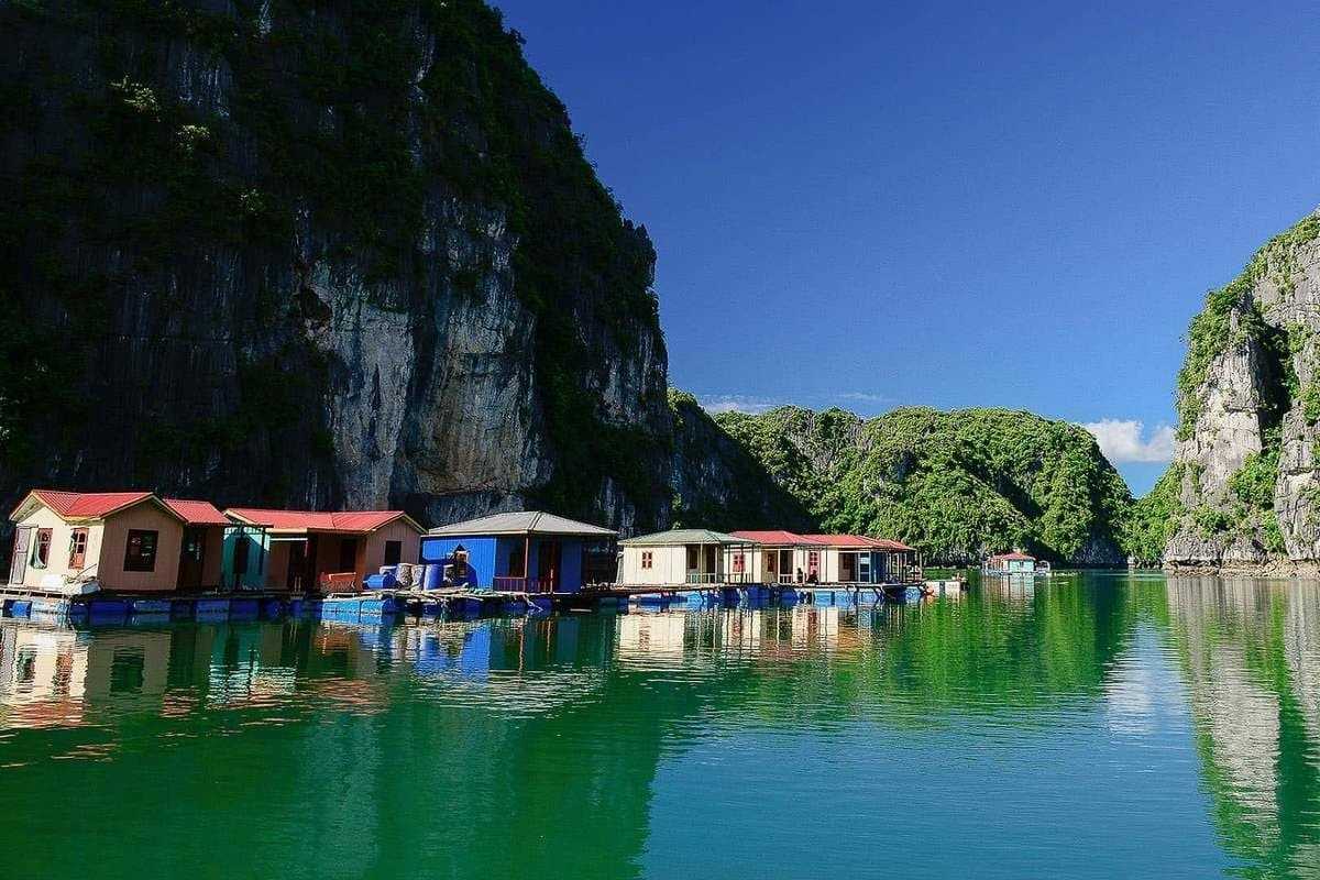 Vung Vieng Fishing Village on Halong Bay tranquil homes Floating homes of Vung Vieng Fishing Village on Halong Bay surrounded by limestone cliffs and calm emerald water