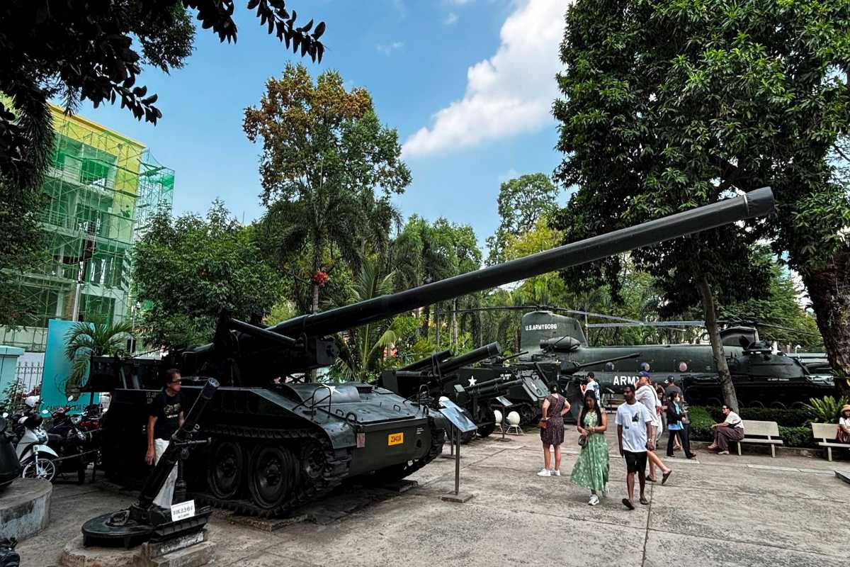 War Remnants Museum Visitors at Helicopter Exhibit Visitors observing a military helicopter exhibit outdoors at the War Remnants Museum in Ho Chi Minh City