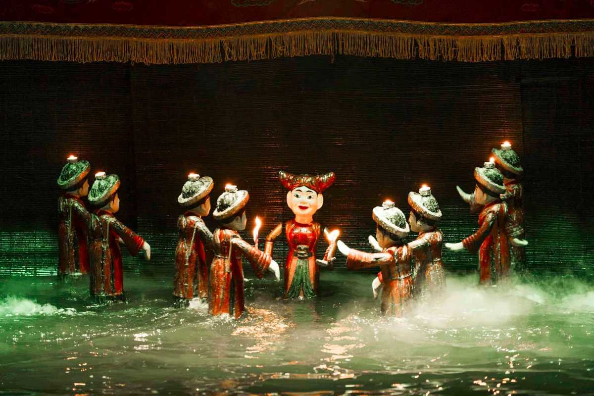 Water Puppets Holding Offerings in Show Puppets carrying fruit offerings on the water stage during a ceremonial scene