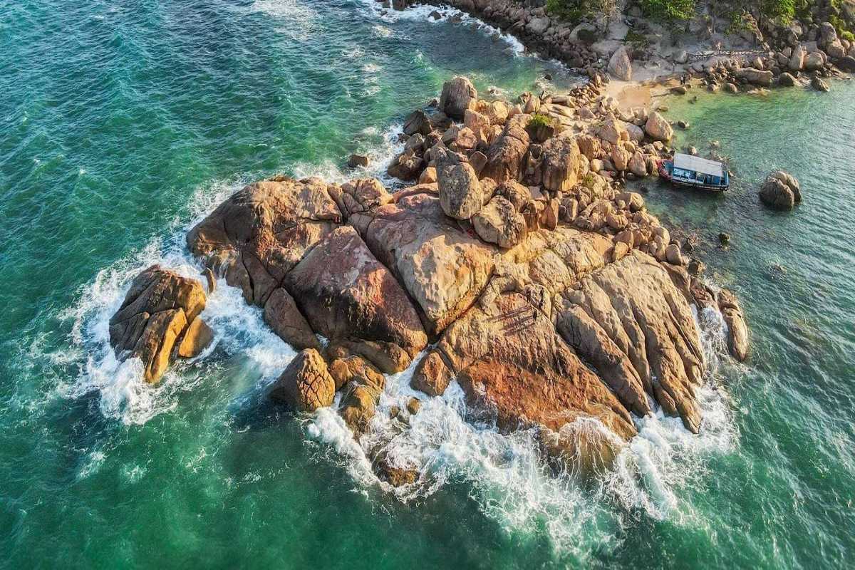 Wave splashing on granite rocks at Hon Chong Promontory Ocean waves crashing against granite boulders at Hon Chong Promontory Nha Trang