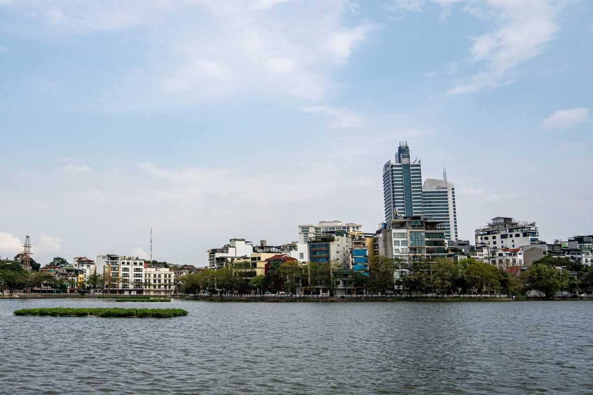 West Lake Hanoi Cityscape with Modern Buildings Modern buildings and waterfront along West Lake Hanoi, reflecting in the calm water at daytime