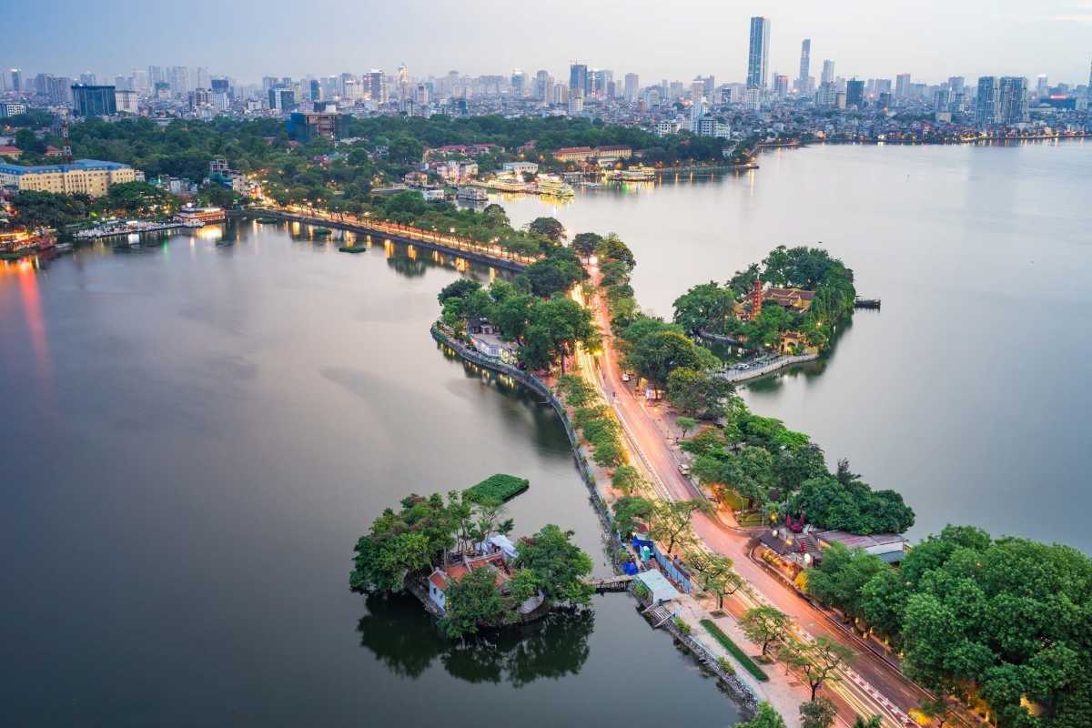 West Lake Hanoi Scenic View from Above Aerial view of West Lake Hanoi with surrounding greenery and city skyline in the background