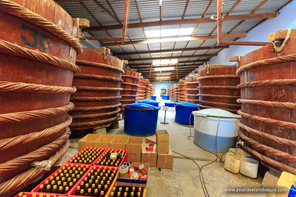 Worker Handling Fermentation Barrels Factory worker managing fermentation barrels at Traditional Phu Quoc Fish Sauce production