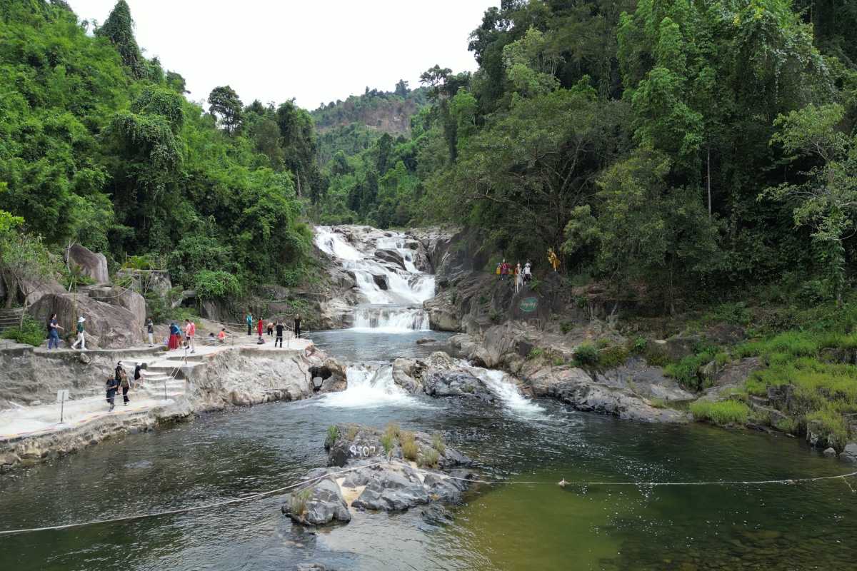 Main Cascade View of Yang Bay Waterfall Wide view of the main waterfall cascade at Yang Bay with visitors exploring the rocky banks