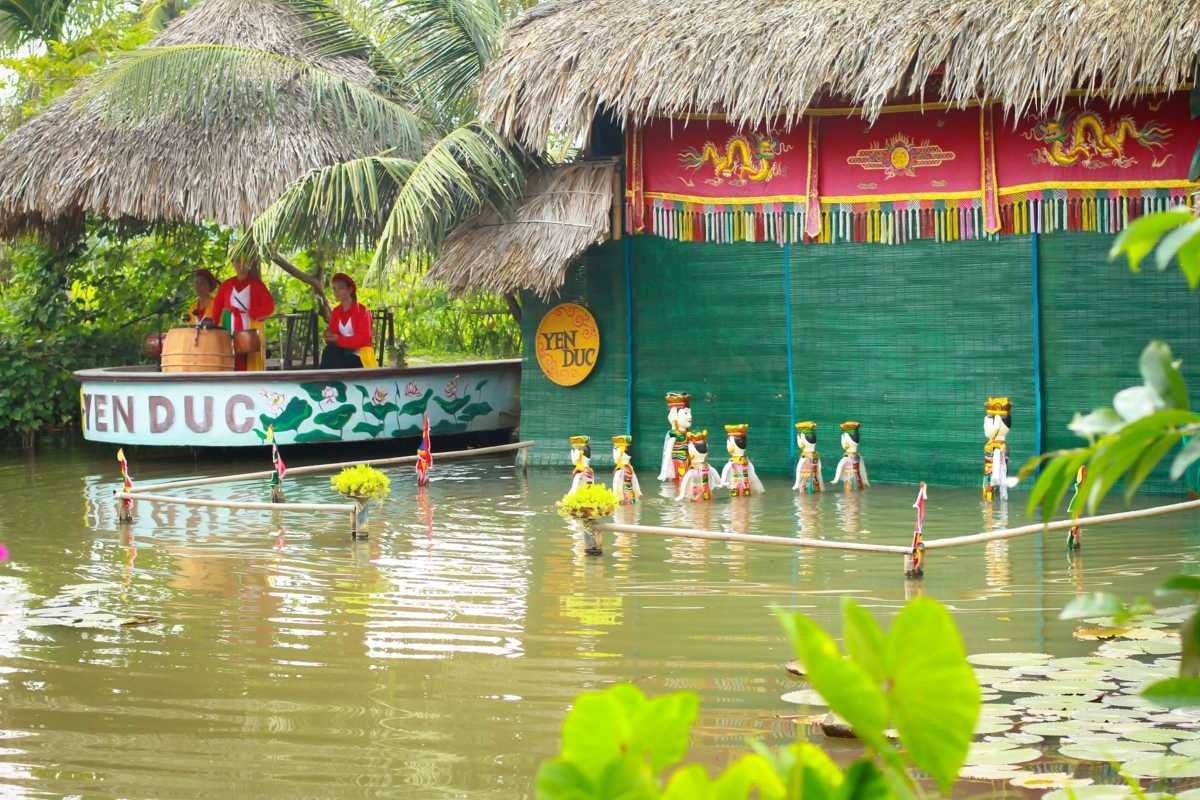 Traditional House and Lotus Pond at Yen Duc Village Traditional wooden house overlooking a lotus pond surrounded by greenery in Yen Duc Village.