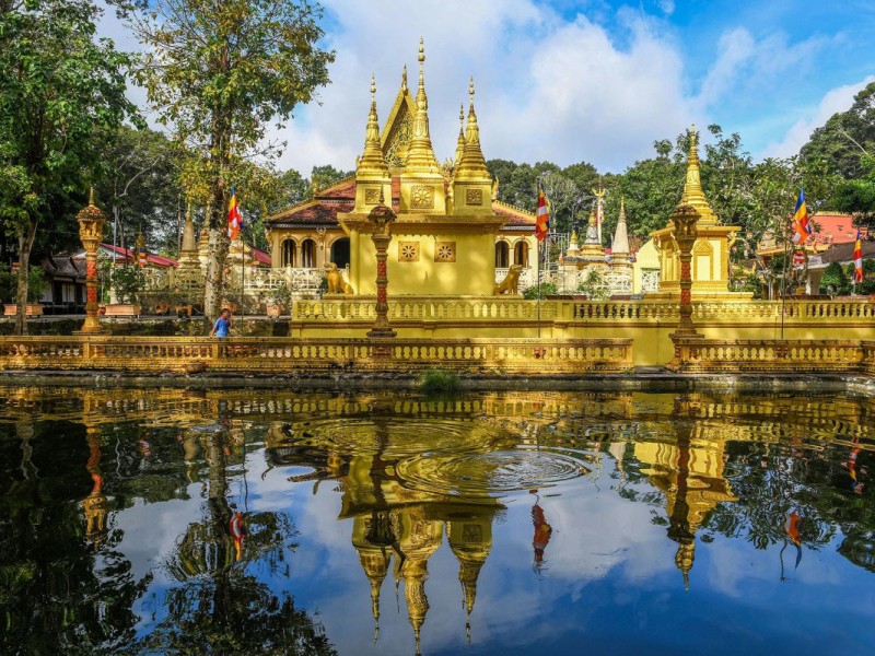 Ang Pagoda in Tra Vinh reflected in a pond, showcasing its Khmer architectural beauty.