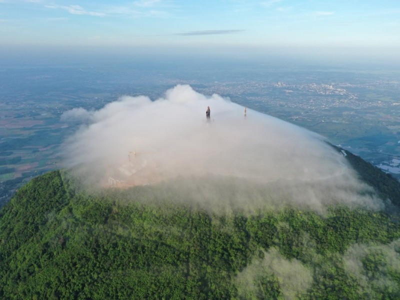 The peak of Ba Den Mountain covered in mist and clouds, offering a mystical view of Tay Ninh.