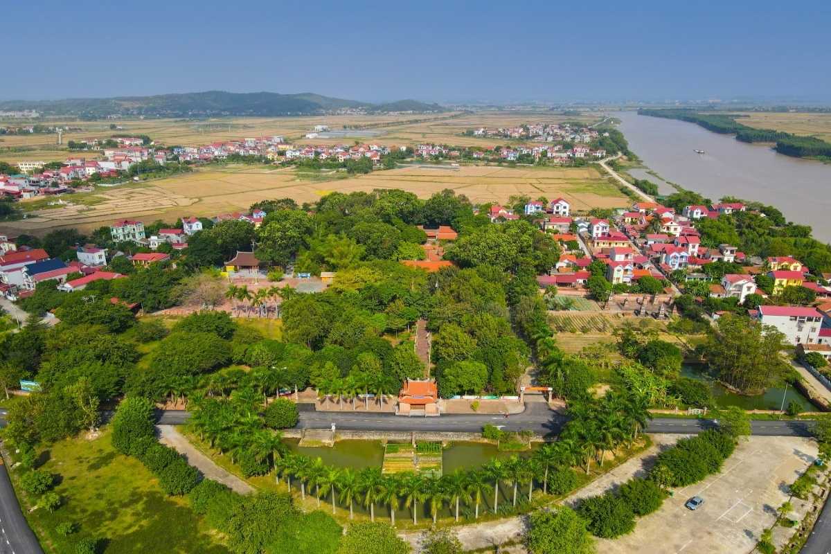Bac Giang Travel Aerial View of Historical Temple and Village Bac Giang Travel features aerial view of a historic temple complex surrounded by a small village and rice fields