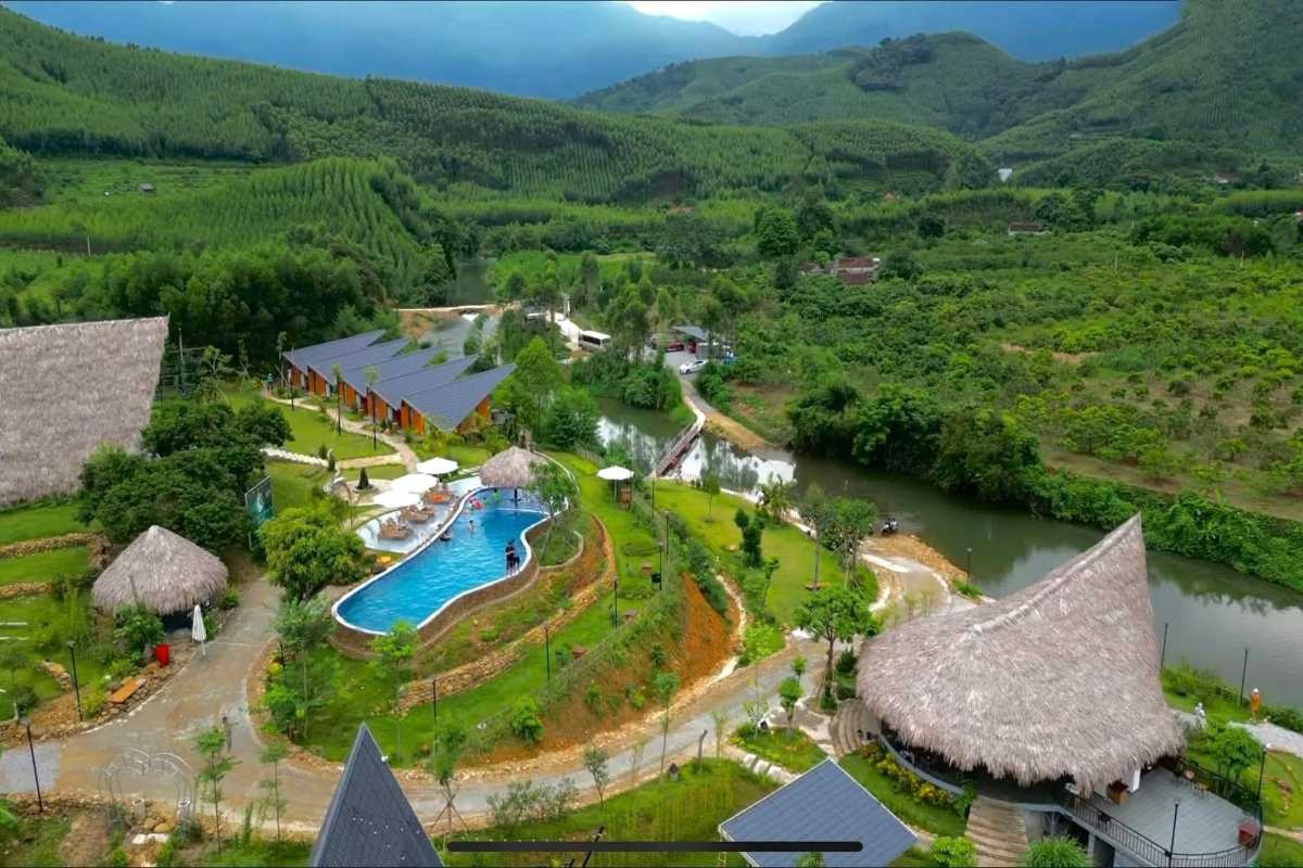 Bac Giang Travel Eco Resort with Swimming Pool and Greenery Bac Giang Travel shows an eco resort with a swimming pool surrounded by trees, hills, and winding paths