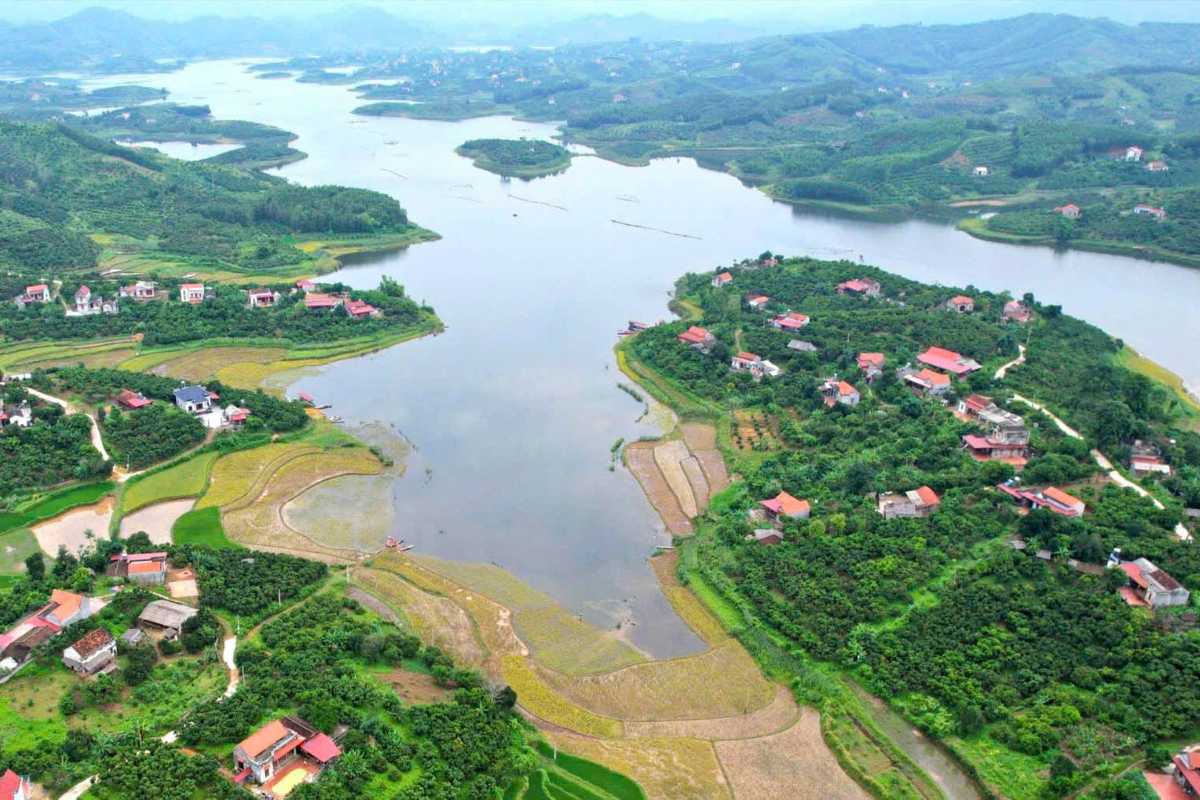 Bac Giang Travel Tourist Boats on Calm Lake Bac Giang Travel features tourists enjoying leisurely boat rides on a calm lake bordered by green mountains