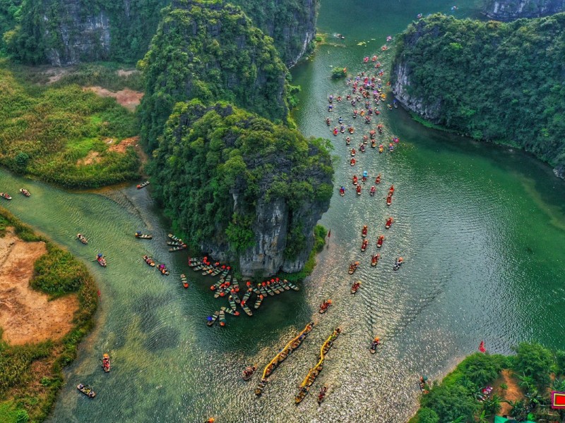 Aerial view of Trang An boat trip in Ninh Binh, showcasing limestone cliffs and tranquil rivers.