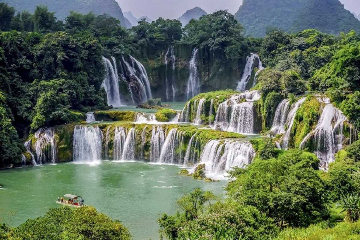 Cao Bang Travel Guide Ban Gioc Waterfall Landscape Wide view of Ban Gioc Waterfall cascading through green forests and rocks in Cao Bang province