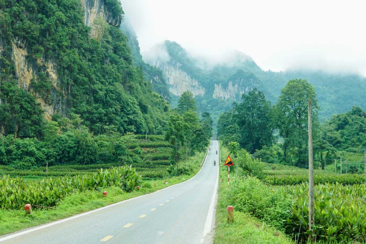Cao Bang Travel Guide Peaceful Lake and Limestone Peaks Tranquil lake reflecting towering limestone peaks under a blue sky in Cao Bang province