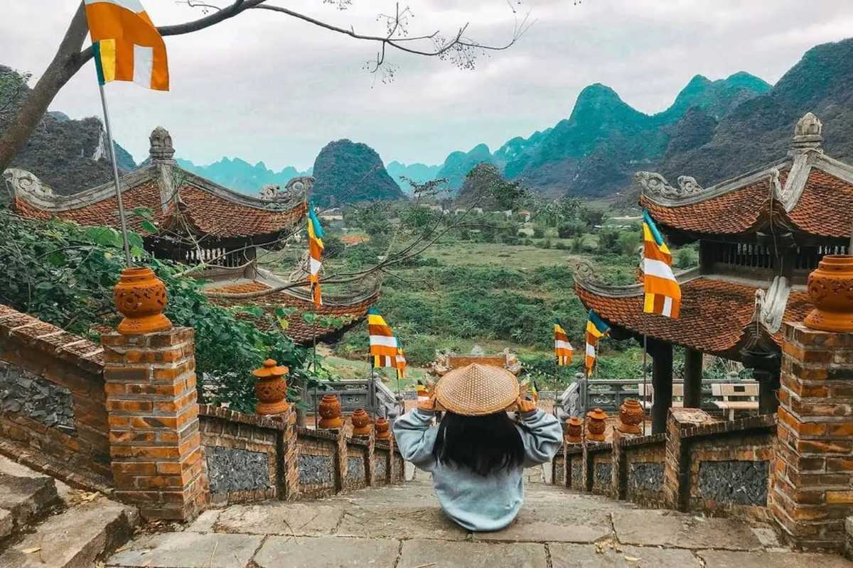 Cao Bang Travel Guide Limestone Mountain with Natural Arch Majestic limestone mountain with natural arch formation under a partly cloudy sky in Cao Bang