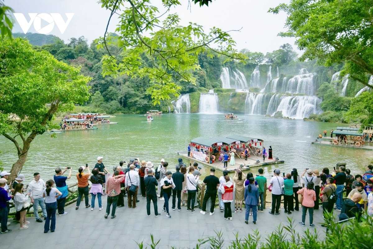 Cao Bang Travel Guide Tourist Boats at Ban Gioc Waterfall Tourists on bamboo boats enjoying close views of Ban Gioc Waterfall with mist and forest backdrop in Cao Bang