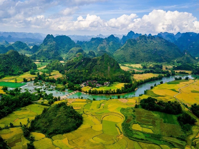 Sweeping landscape view of Cao Bang's lush greenery, winding rivers, and misty mountains.