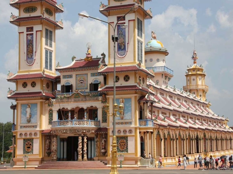 A detailed close-up of the intricate architecture of the Cao Dai Temple in Tay Ninh.