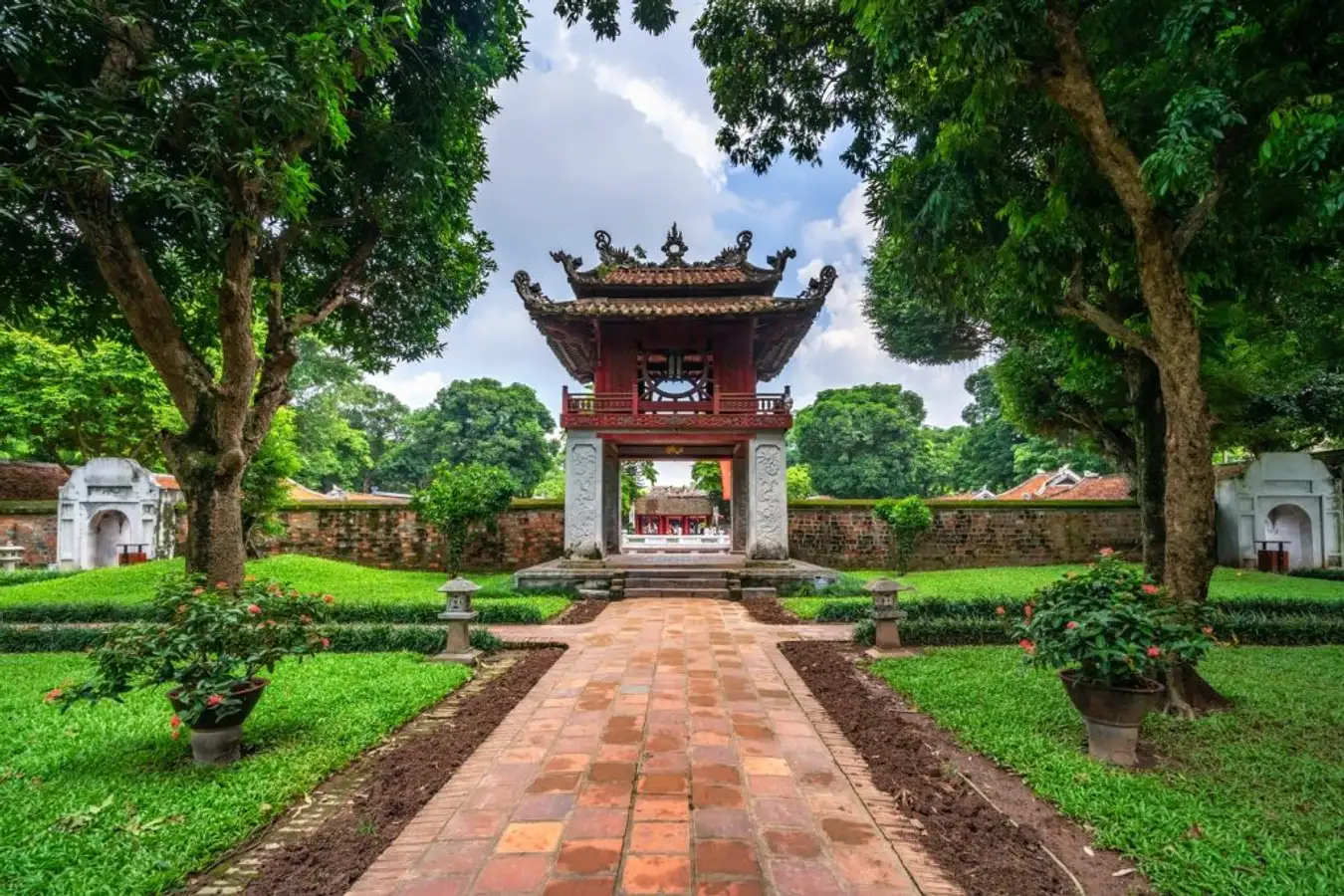 Close-up of Vietnamese temple entrance with bell Detailed view of a Vietnamese temple entrance featuring an ancient bell framed by greenery