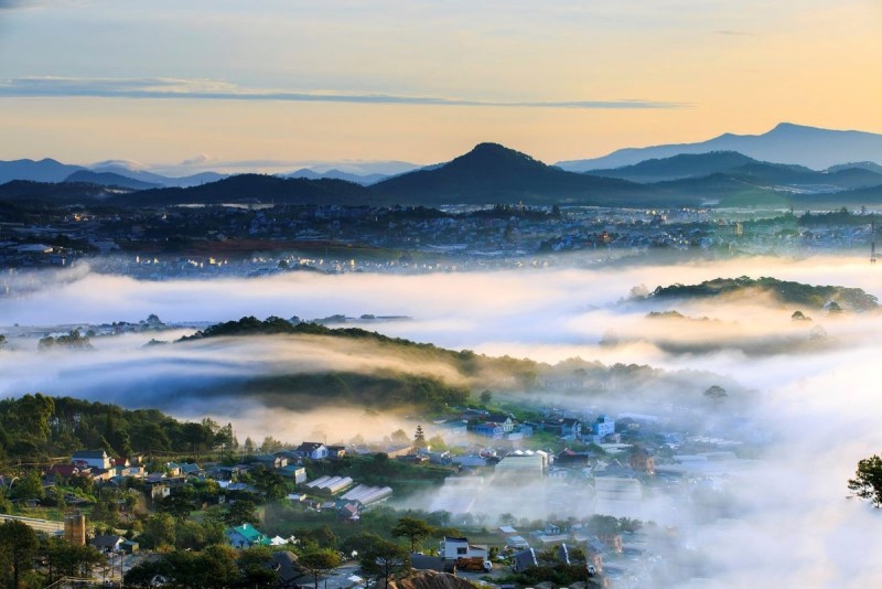 Morning fog over Da Lat city in the highlands of Vietnam with rolling hills and peaceful scenery