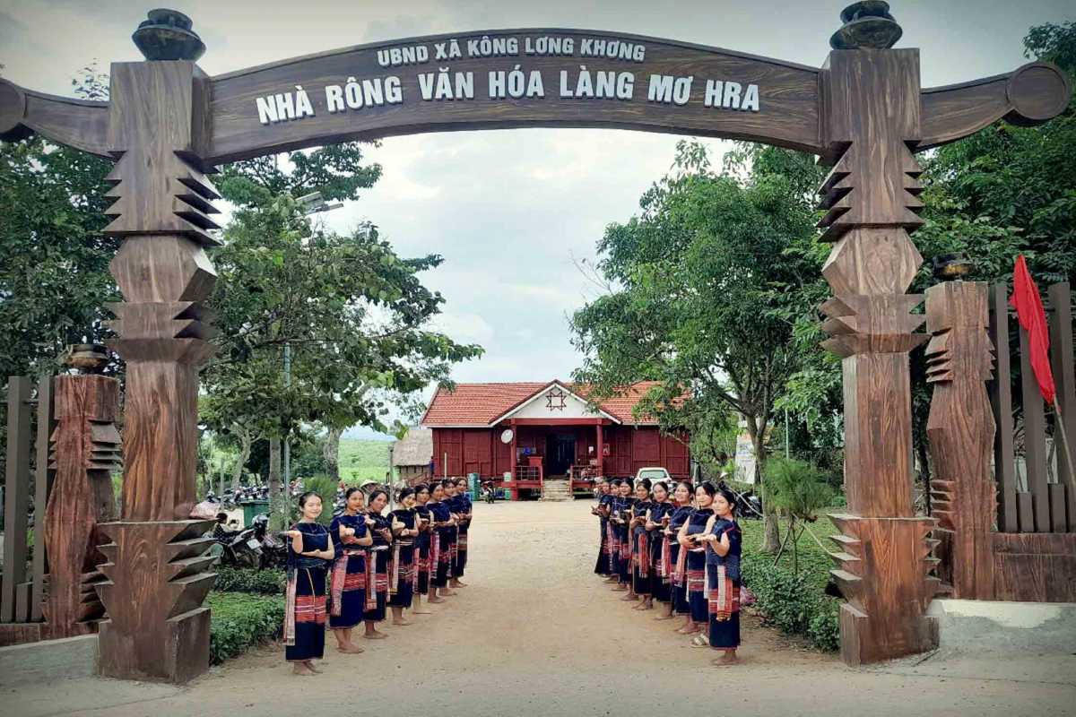 Ethnic Village Entrance Gate in Gia Lai Traditional wooden gate entrance to an ethnic village with women in traditional dress