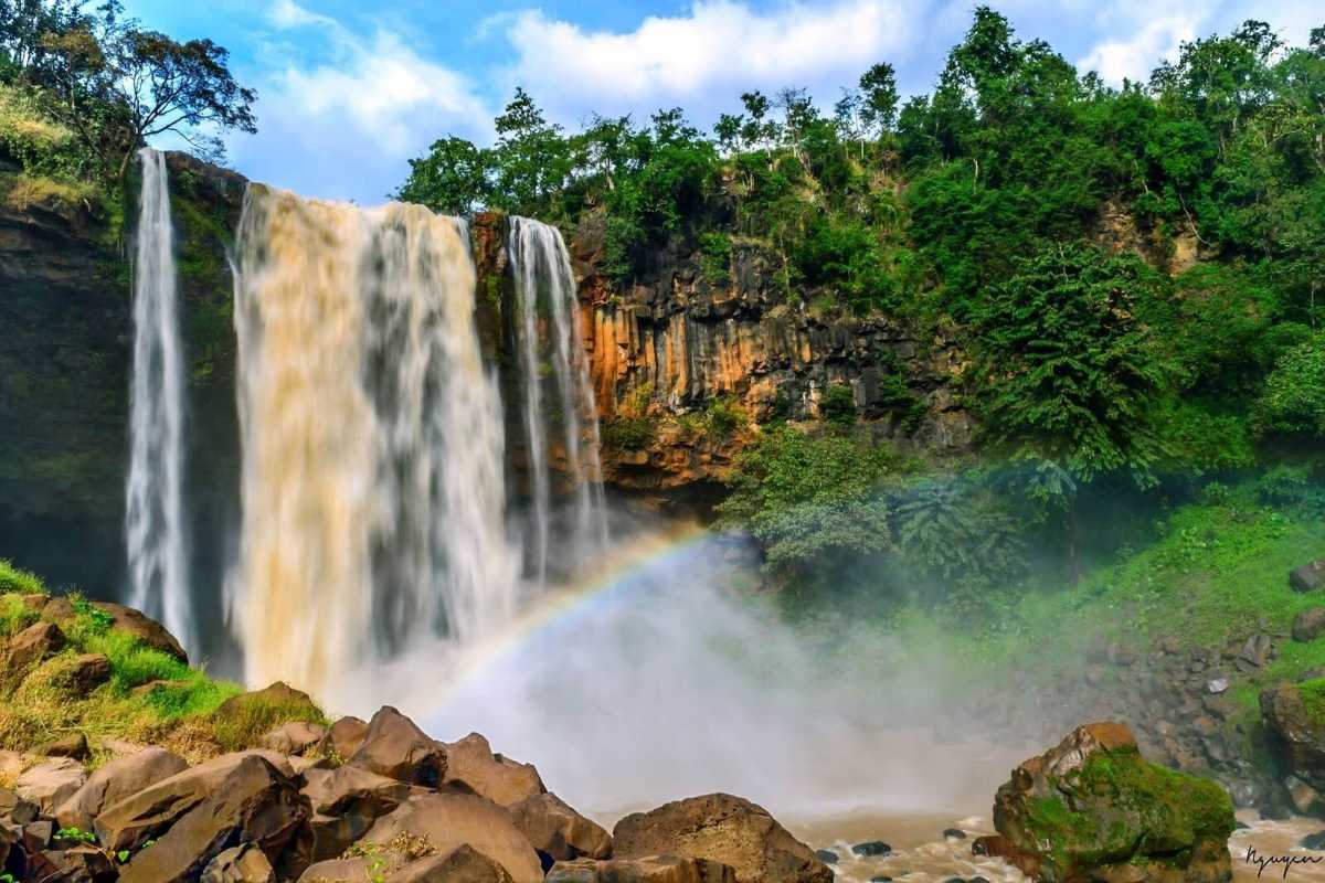Waterfall Visit in Gia Lai with Couple Couple admiring a large waterfall surrounded by tropical vegetation