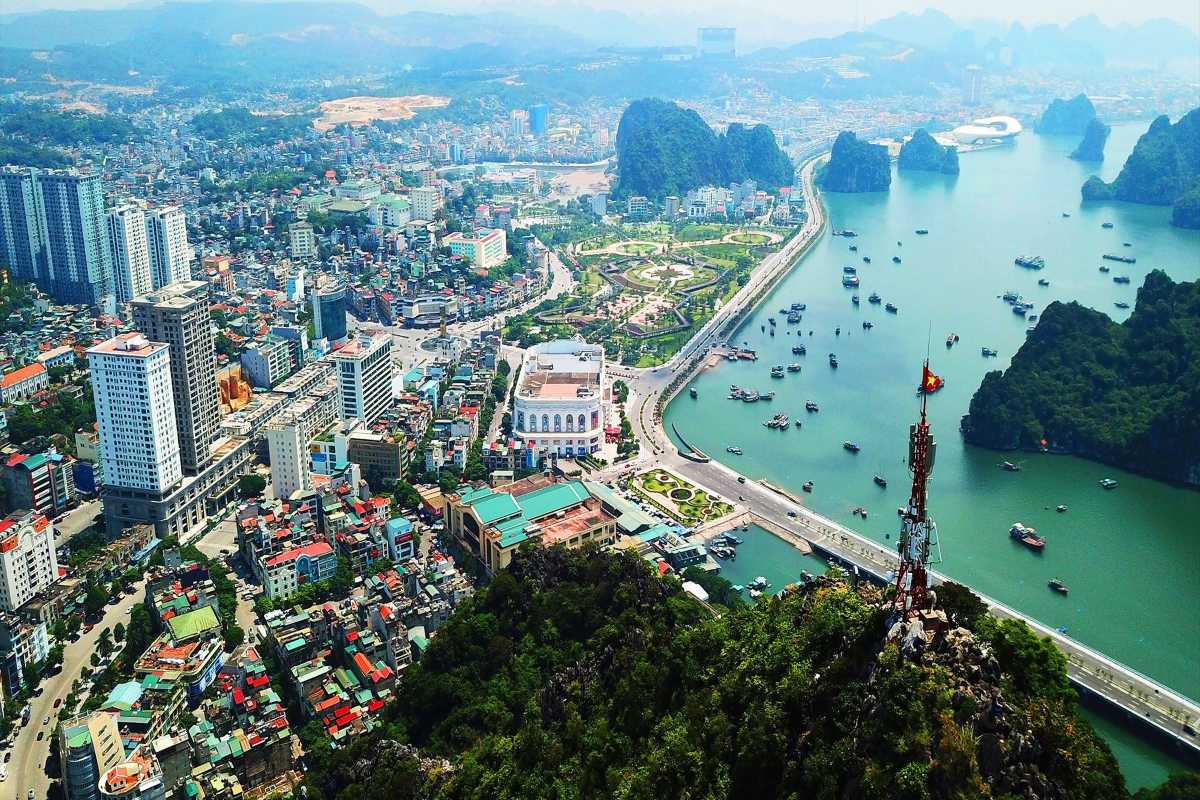 Hai Phong city with limestone karsts and bay at sunrise Early morning view of Hai Phong city, limestone karst hills, and calm bay waters under soft sunrise light
