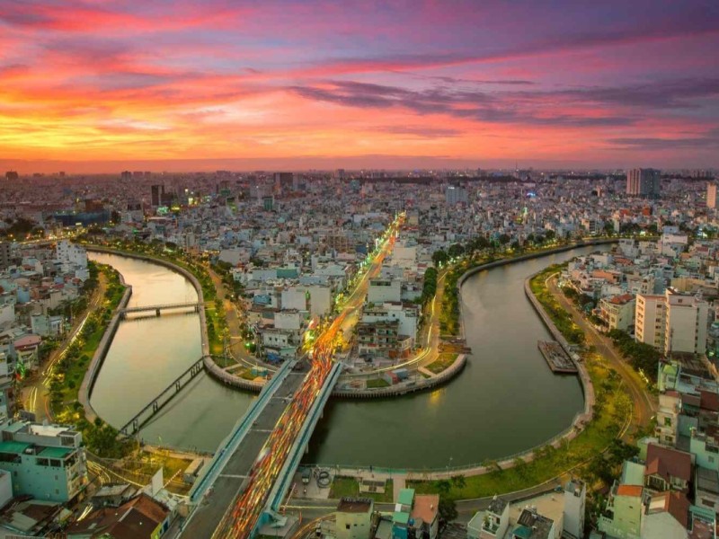 A stunning sunset over the canal and the expansive cityscape of Ho Chi Minh City.