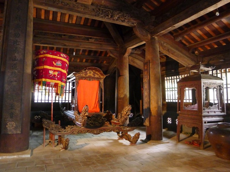 Inside the Tho Ha communal house with traditional wooden architecture and ceremonial objects