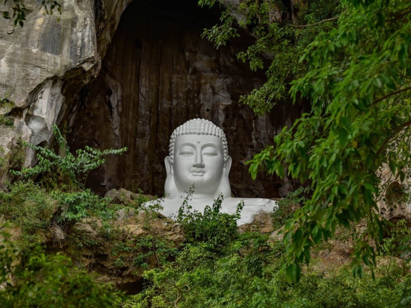 A large white Buddha statue carved inside Kim Son Cave in Thanh Hoa