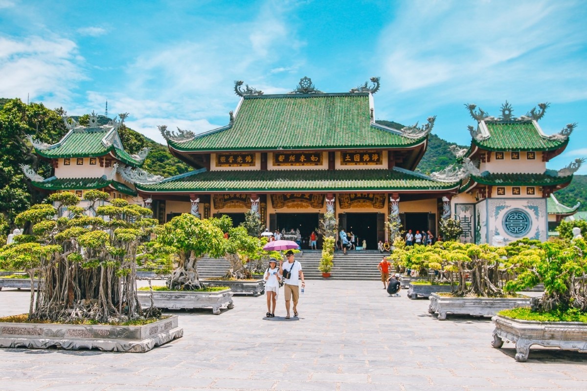 Linh Ung Pagoda at Son Tra Peninsula in Da Nang, Vietnam showcasing beautiful architecture with green rooftops and bonsai trees.