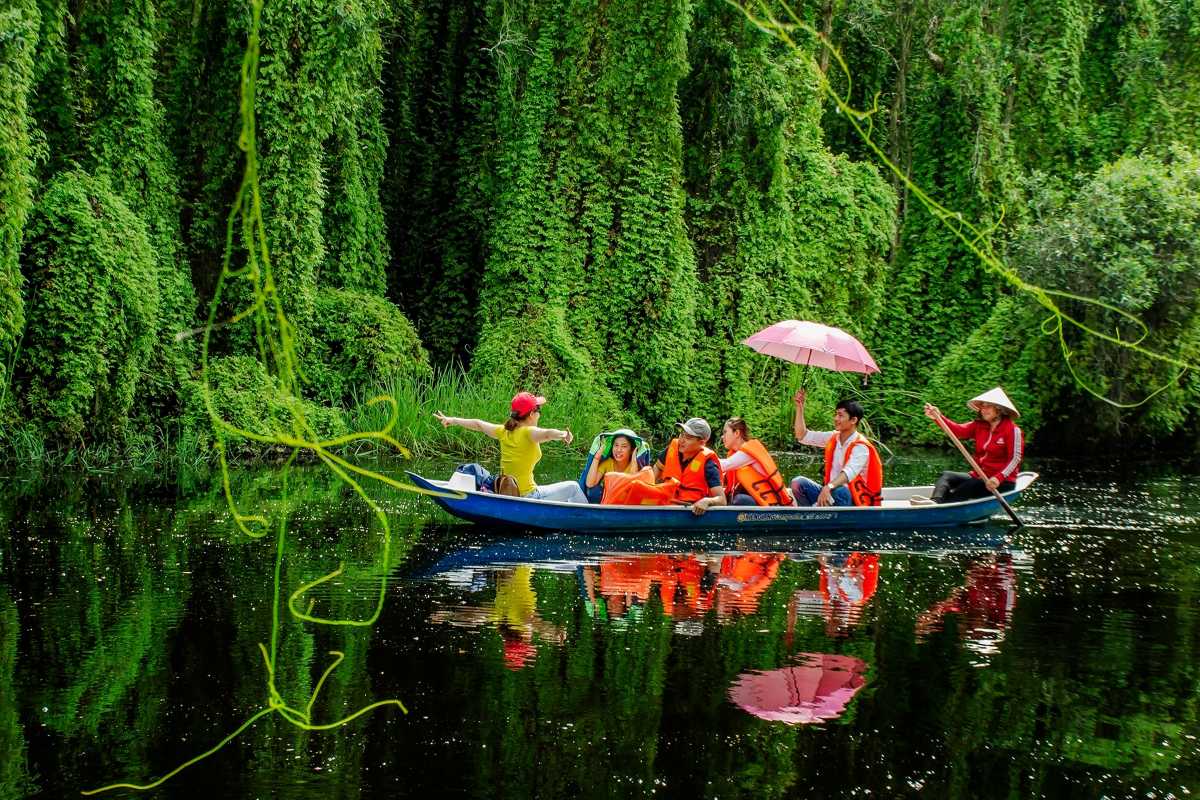 Long An Travel Guide flower boats moored at riverbank Flower-decorated boats docked along a calm riverbank in the Long An Travel Guide