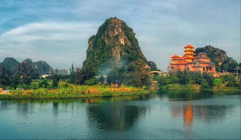 Scenic view of the Marble Mountains in Da Nang, Vietnam, surrounded by lush greenery and reflecting water.