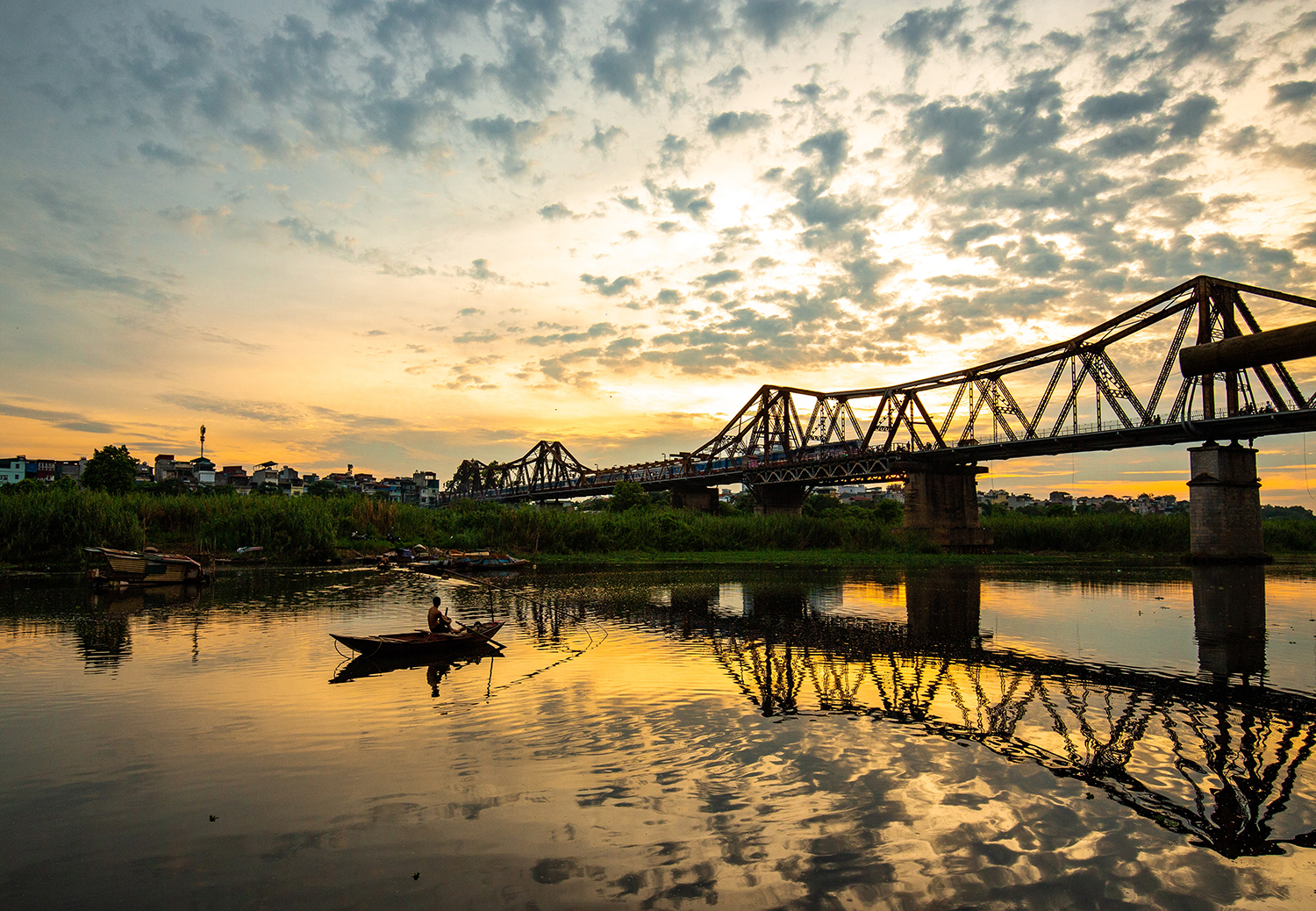 Night view of brightly lit bridges over river in Vietnam Illuminated modern bridges crossing a river in Vietnam with city lights glowing at night