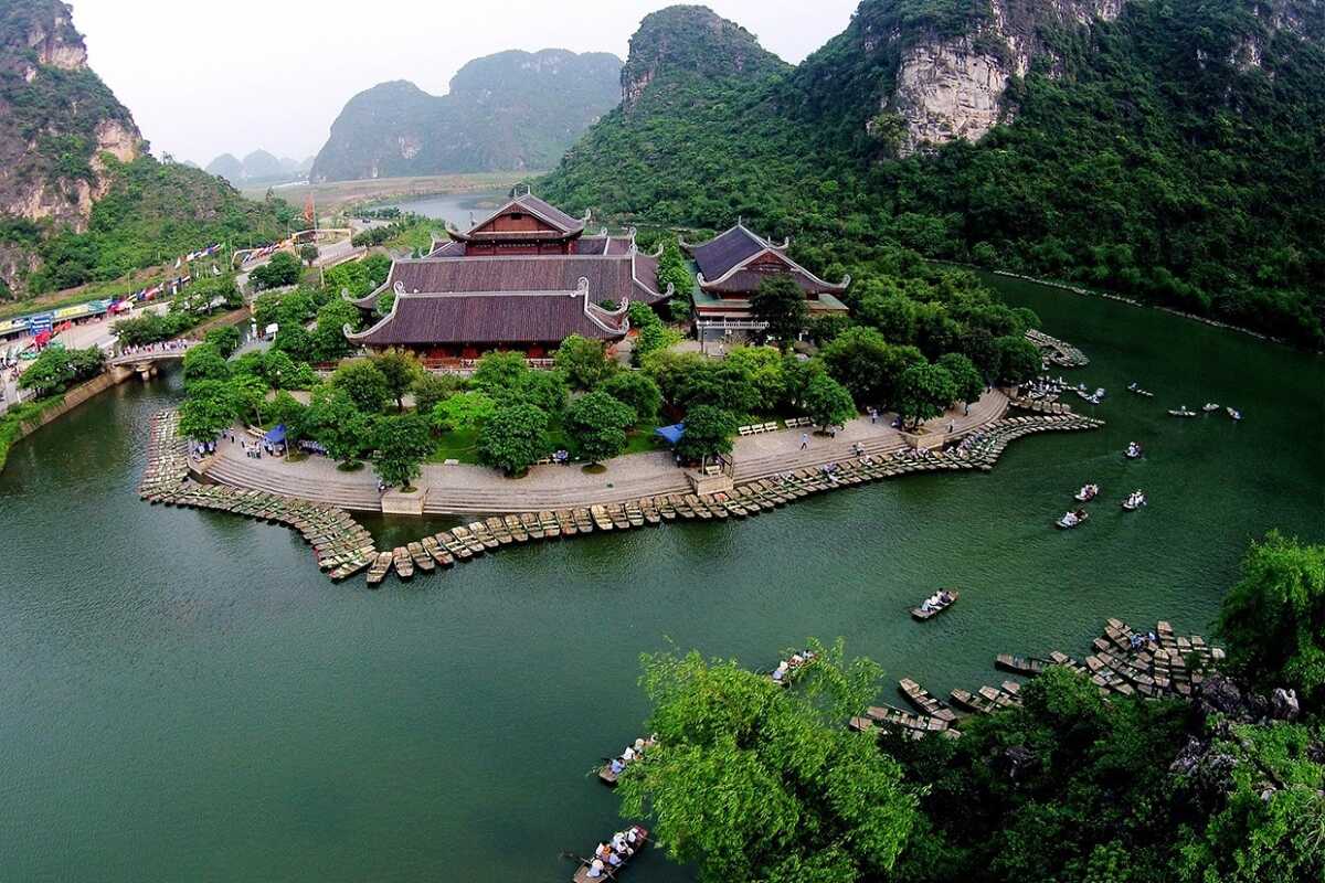 Ninh Binh Vietnam Scenic Temple Surrounded by Limestone Karsts Ninh Binh Vietnam features a historic temple complex nestled amid towering limestone karsts and winding rivers.