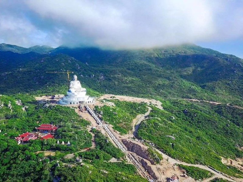 Ong Nui Temple (Linh Phong Temple) with large Buddha statue and scenic mountain backdrop in Binh Dinh