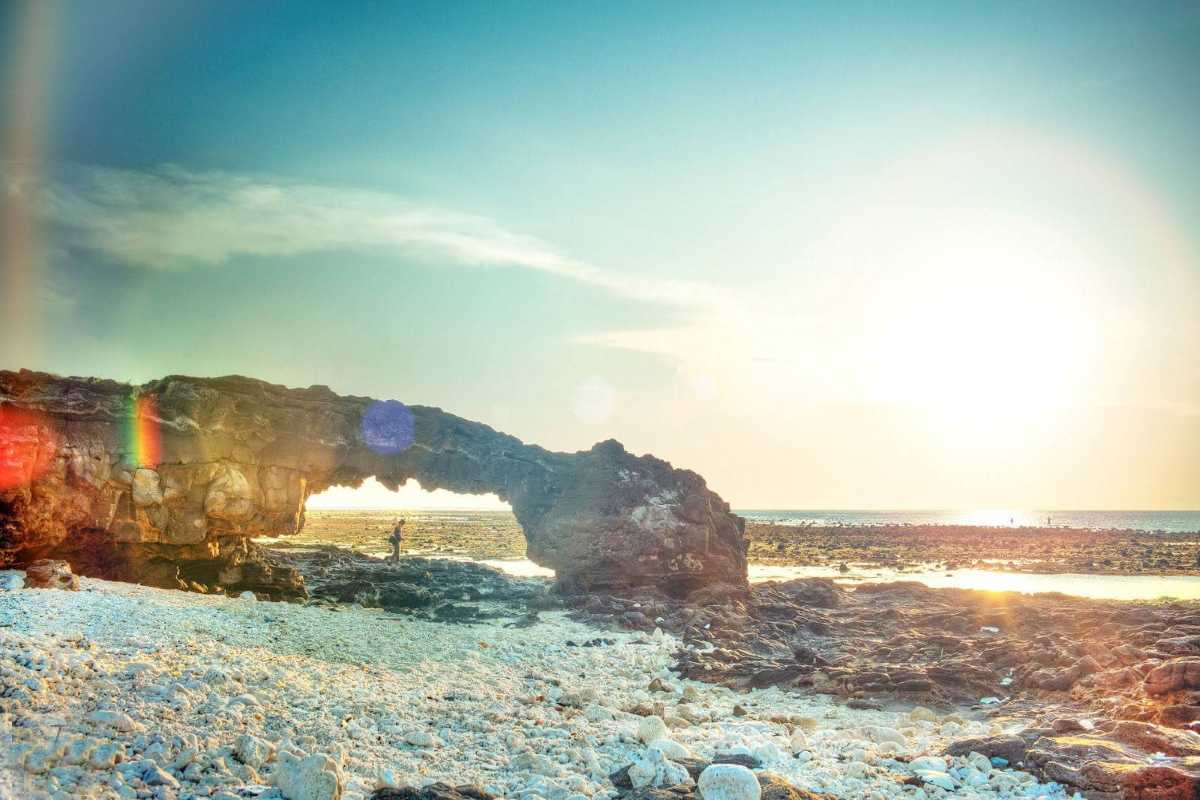 Quang Ngai Volcanic Rock Arch and Ocean Shoreline Natural volcanic rock arch formation on the ocean shoreline with clear skies in Quang Ngai, Vietnam.